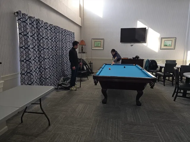 a room with furniture pool table and a flat screen tv
