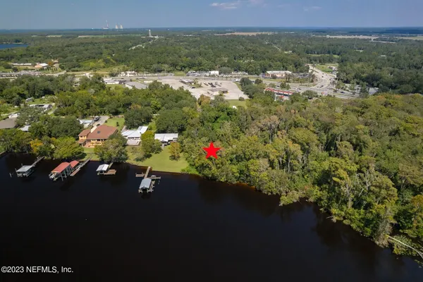 an aerial view of residential houses with outdoor space and trees