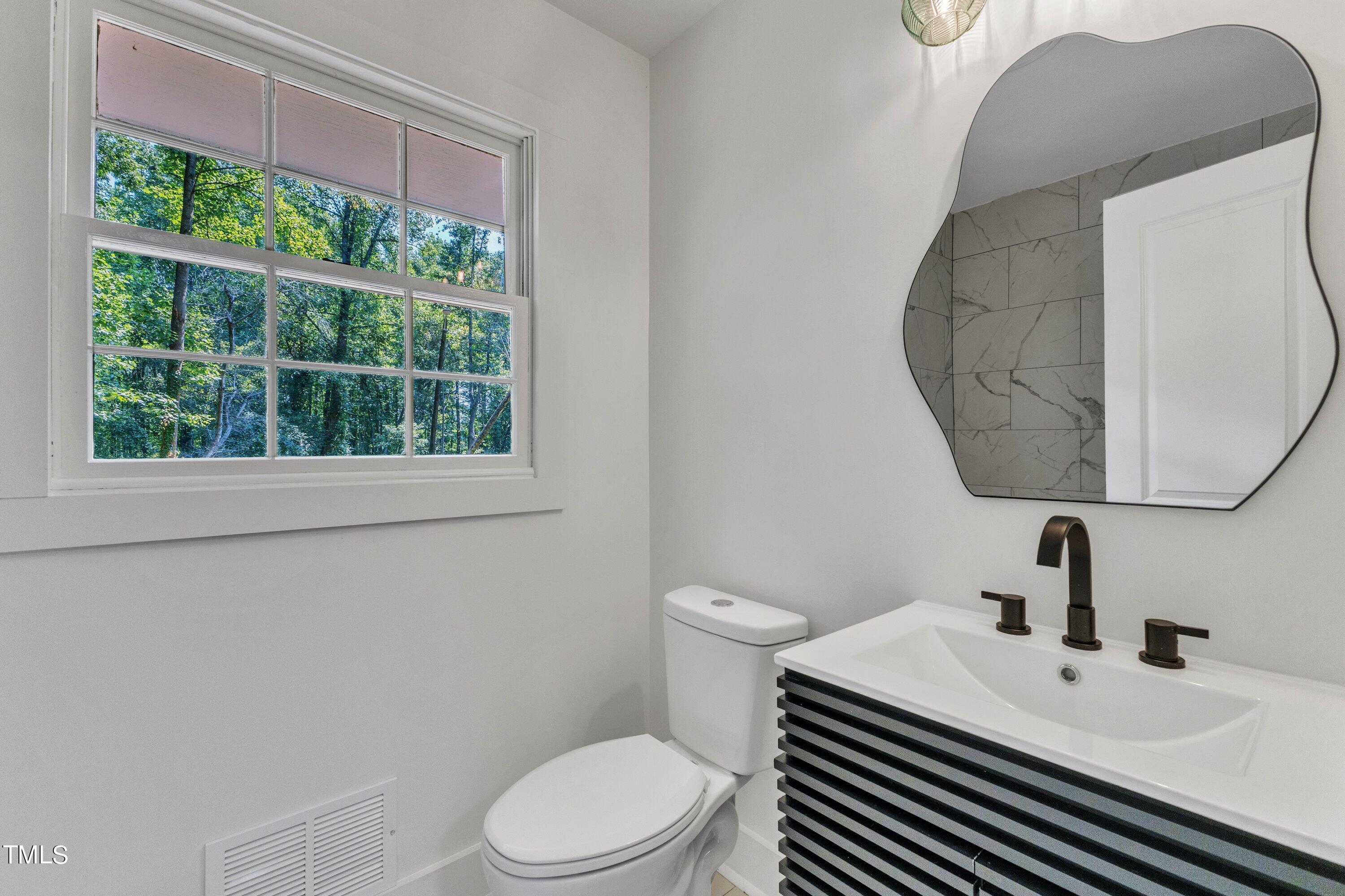 3023 Creech Road Garner, NC 27529 - Photo 31 of 42 a bathroom with a sink a toilet and a window