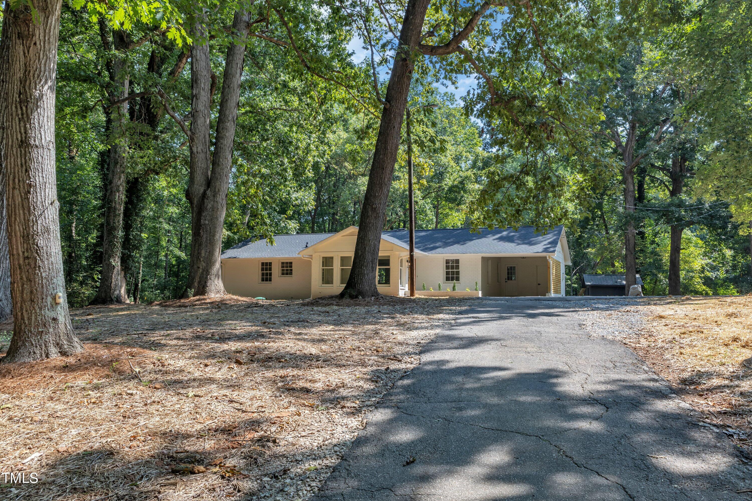 3023 Creech Road Garner, NC 27529 - Photo 38 of 42 a view of a house with large trees and a barn