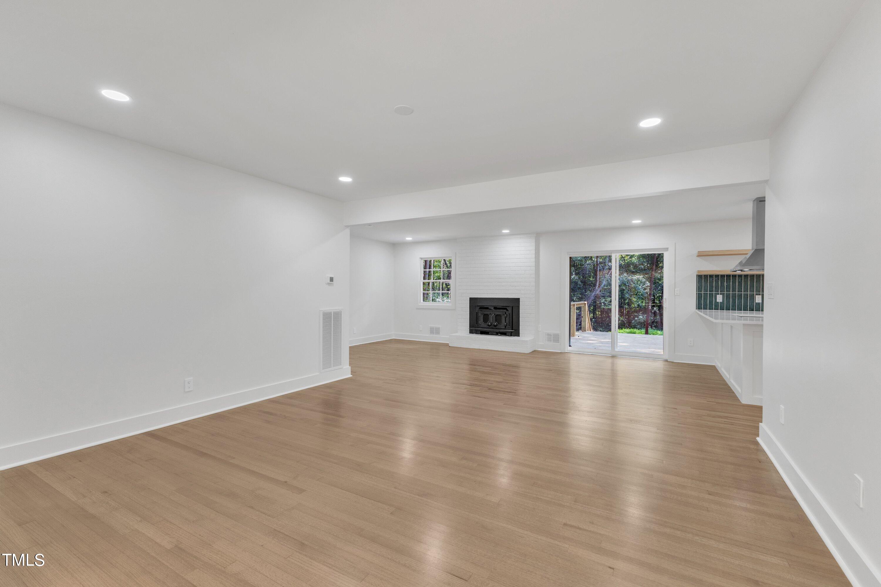 3023 Creech Road Garner, NC 27529 - Photo 8 of 42 a view of an empty room with wooden floor and a window