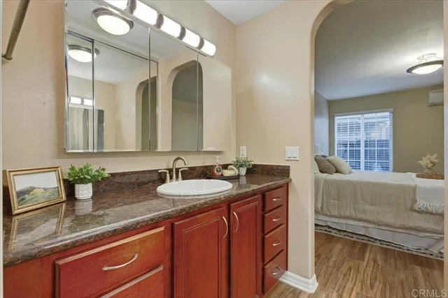 a en suite bathroom with a granite countertop sink and a mirror