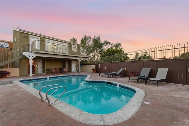 a view of a swimming pool with back yard of a house