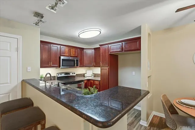 a kitchen with stainless steel appliances granite countertop a sink refrigerator and cabinets