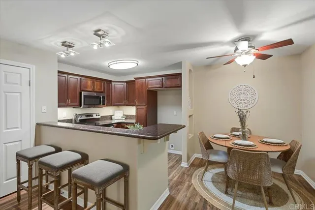 a kitchen with stainless steel appliances a table and chairs in it
