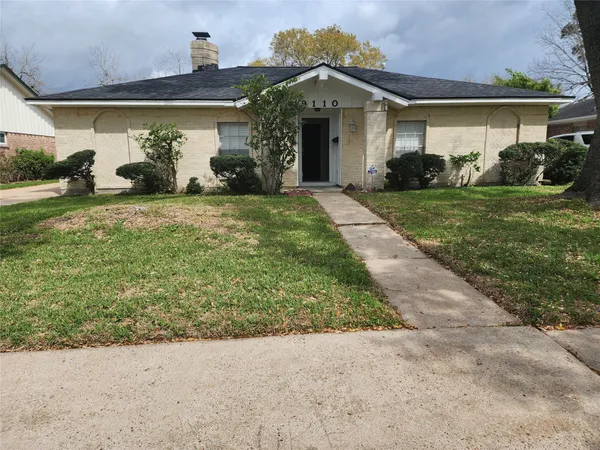a front view of a house with a yard and potted plants