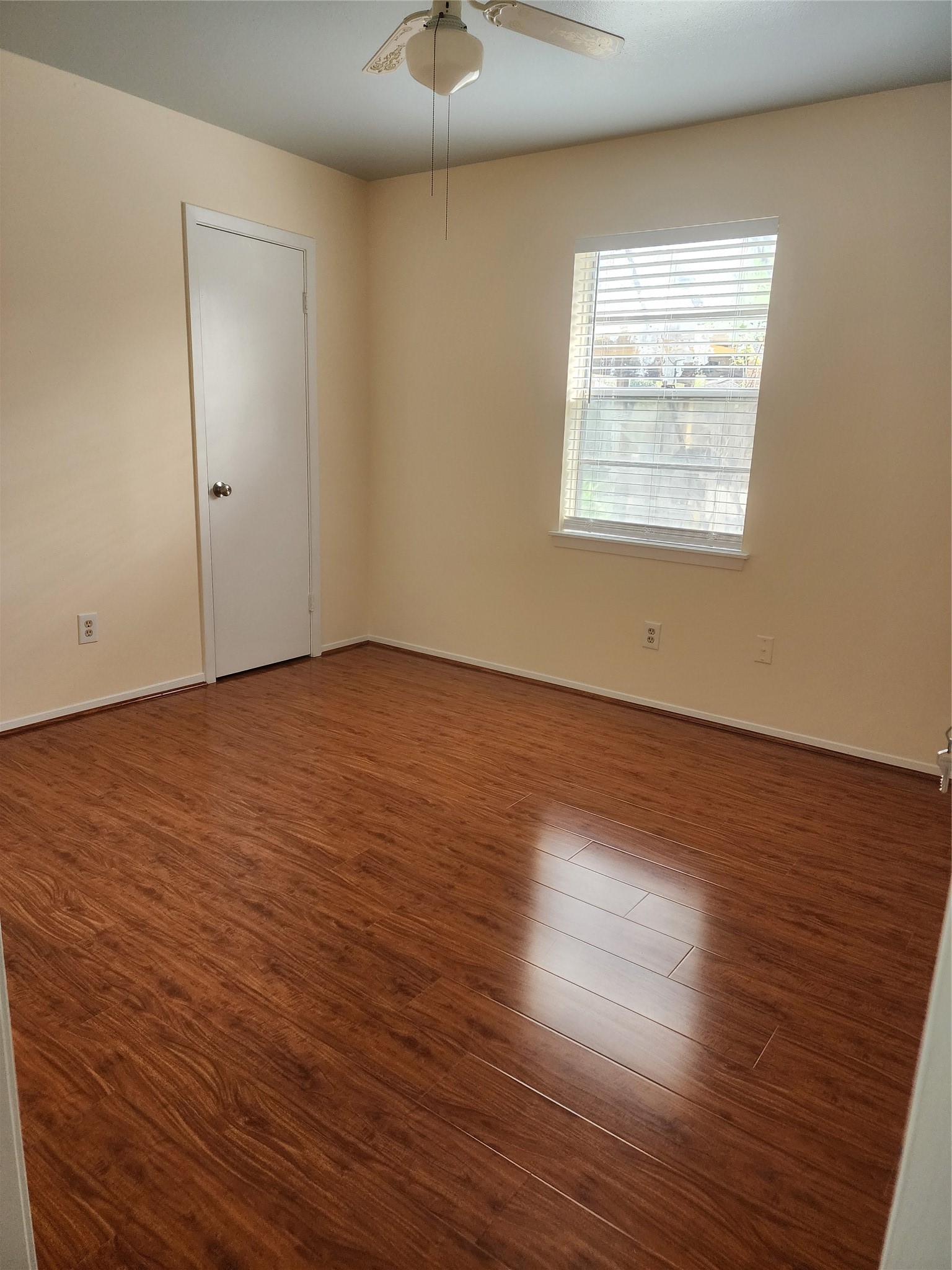 9110 Grape Street Houston, TX 77036 - Photo 11 of 17 an empty room with wooden floor chandelier fan and windows