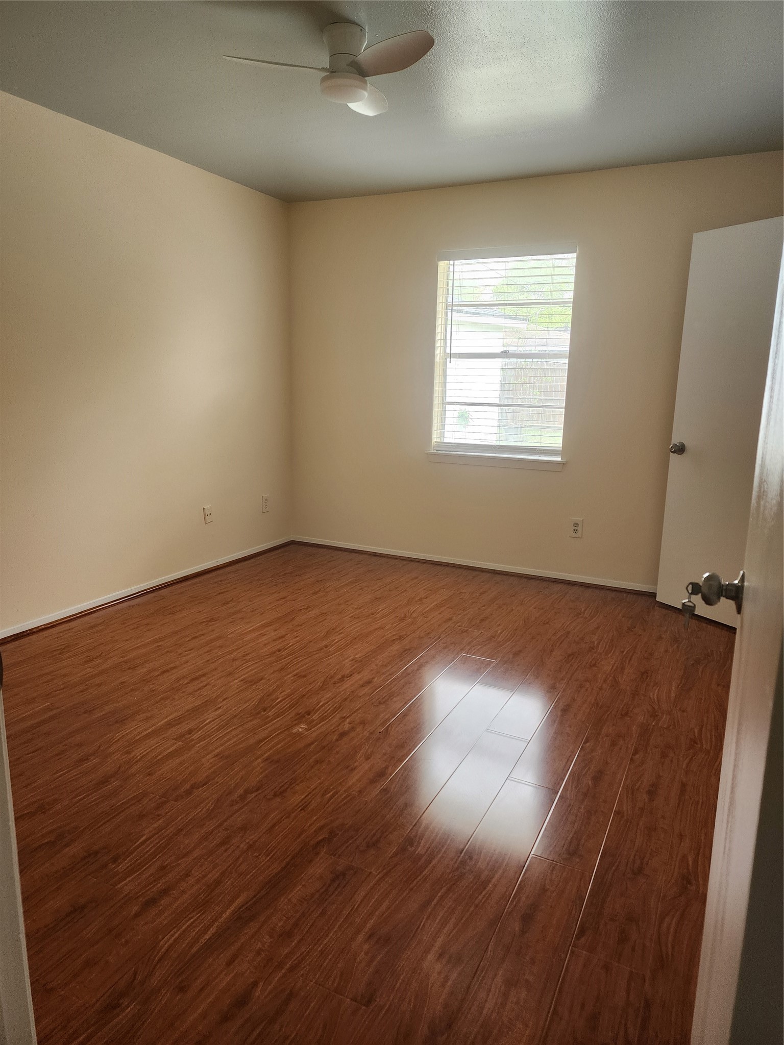 9110 Grape Street Houston, TX 77036 - Photo 13 of 17 an empty room with wooden floor and windows