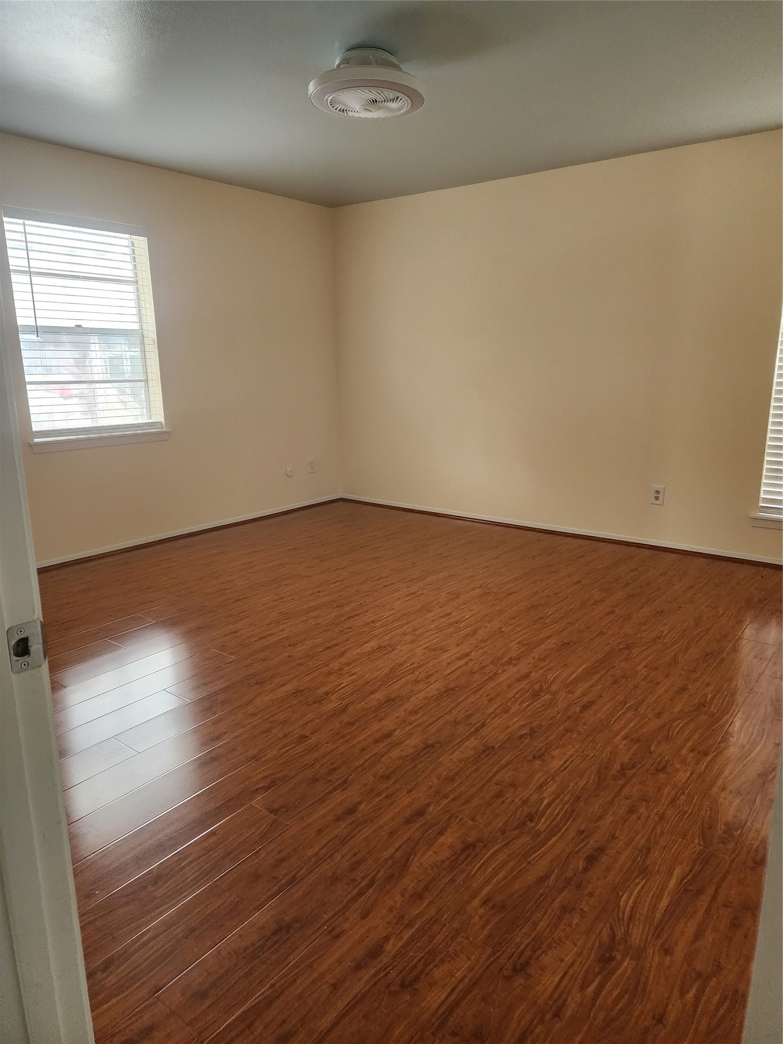 9110 Grape Street Houston, TX 77036 - Photo 7 of 17 an empty room with wooden floor and windows