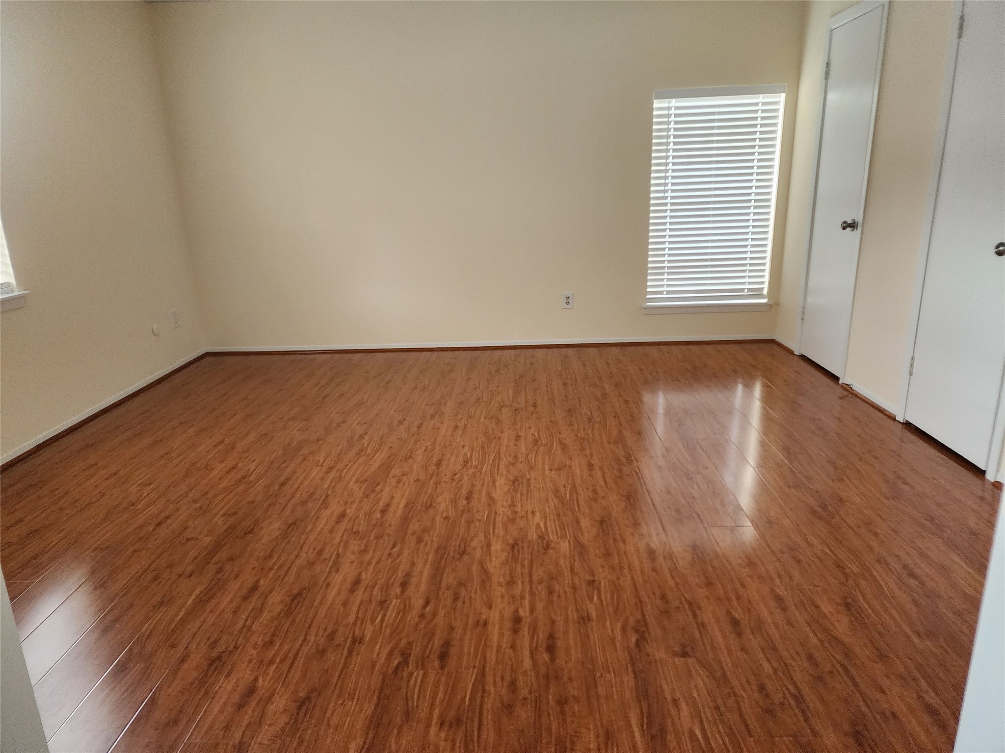 9110 Grape Street Houston, TX 77036 - Photo 8 of 17 an empty room with wooden floor and windows