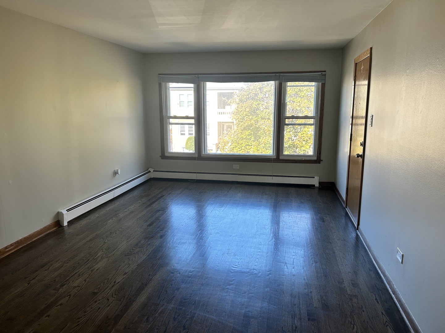 5645 West 63rd Place, Unit 2 Chicago, IL 60638 - Photo 2 of 13 an empty room with wooden floor and windows