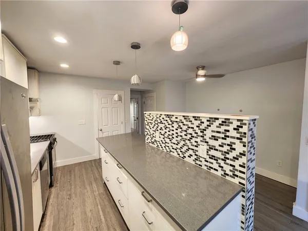a kitchen with granite countertop a stove a sink and a refrigerator