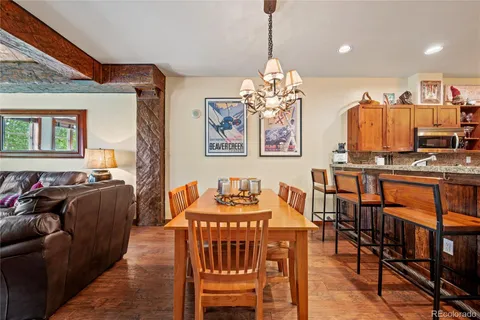 a view of a dining room with furniture a chandelier and wooden floor
