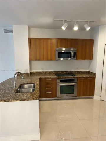 a kitchen with granite countertop a stove and a sink