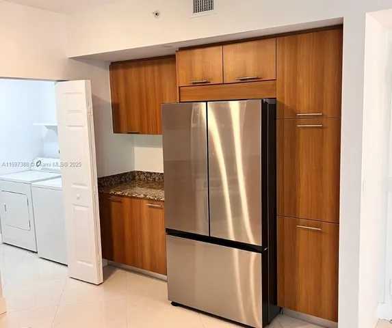 a kitchen with stainless steel appliances granite countertop a refrigerator and a stove