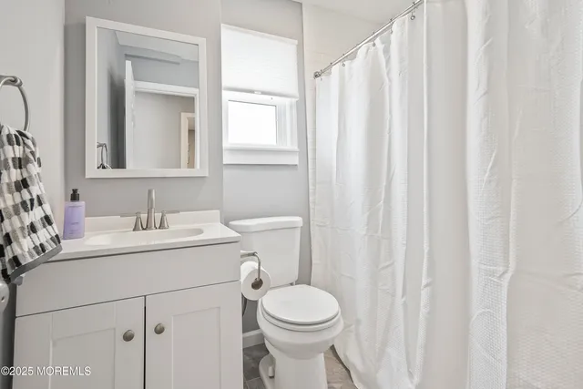 a bathroom with a sink vanity mirror and toilet