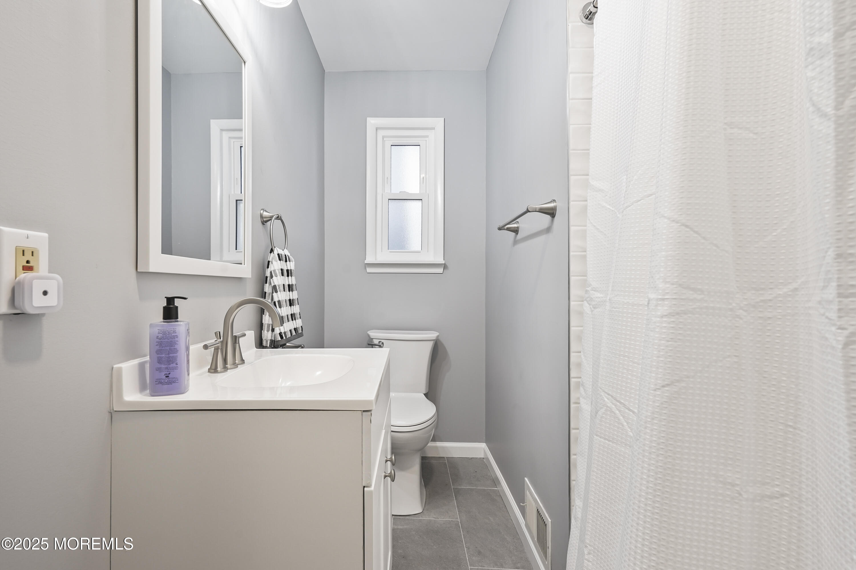 214 Webster Avenue, Unit 1 Seaside Heights, NJ 08751 - Photo 13 of 24 a bathroom with a sink a toilet and a mirror