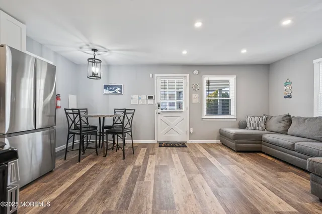 a living room with furniture and a refrigerator