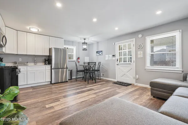 a living room with furniture and a refrigerator