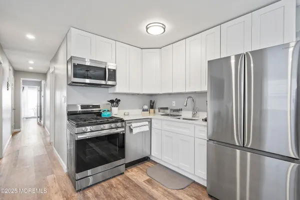 a kitchen with stainless steel appliances a refrigerator sink and microwave