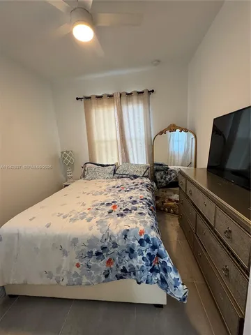 a bedroom with a bed and a large mirror on dresser