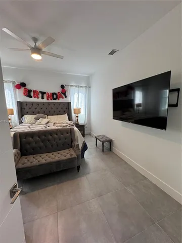 a bedroom with a bed and a flat screen tv