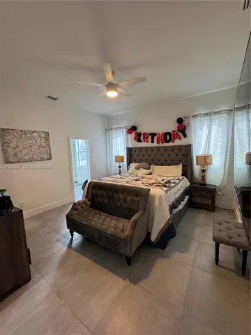a bedroom with a bed couch and a window