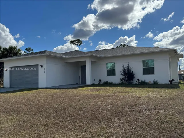 a view of a house with a yard and garage