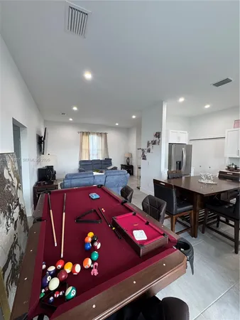 a living room with furniture a pool table and a fireplace