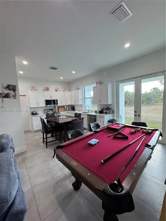 a room with pool table and windows