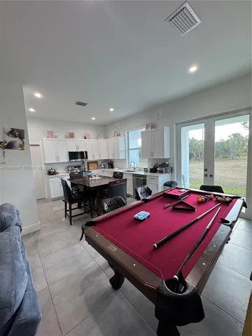 a room with pool table and windows