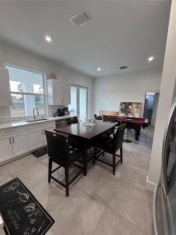 a kitchen with a sink dining table and chairs