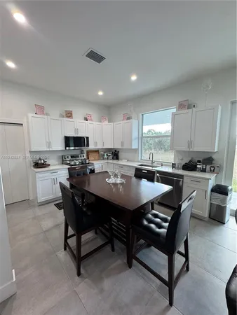 a large kitchen with a table and chairs