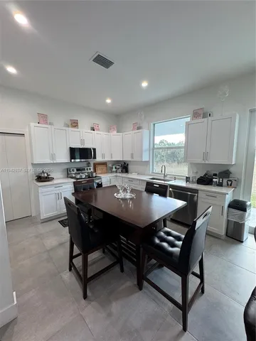 a large kitchen with a table and chairs