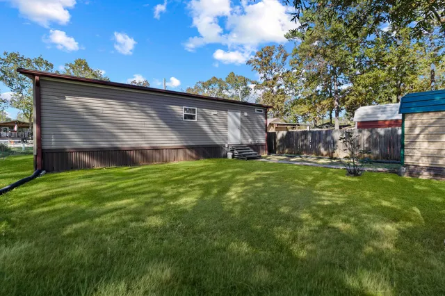 a view of a house with a yard tree and a garden