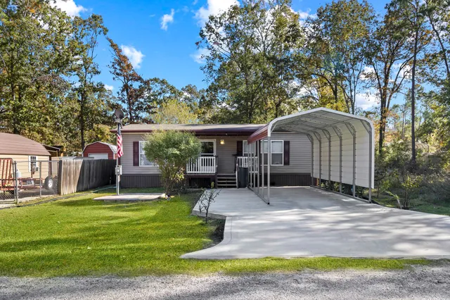 a front view of house with a garden and trees
