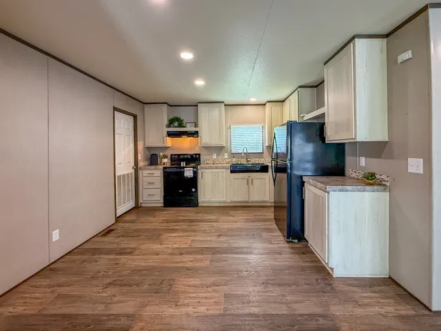 a kitchen with stainless steel appliances granite countertop a refrigerator sink and stove