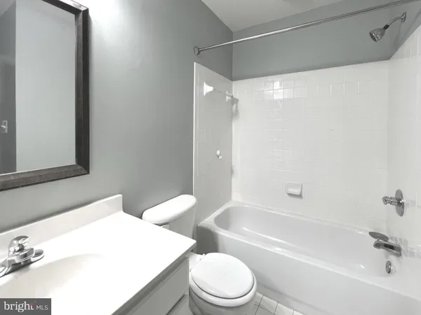 a bathroom with a bathtub shower sink vanity and toilet