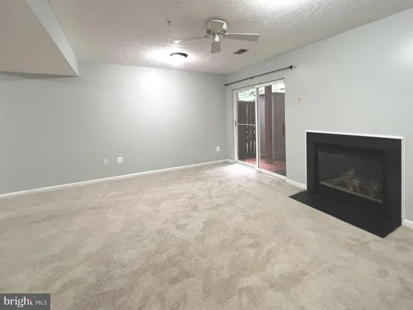 en empty room with windows and fireplace