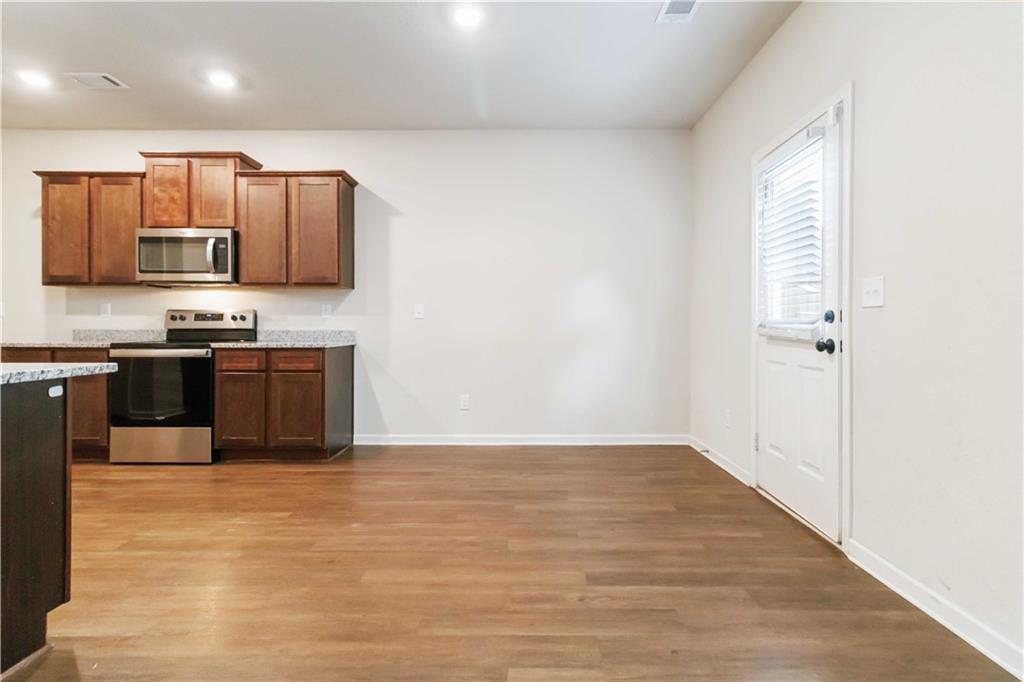 10794 Wheeler Trace Hampton, GA 30228 - Photo 11 of 35 a kitchen with stainless steel appliances a sink and a refrigerator