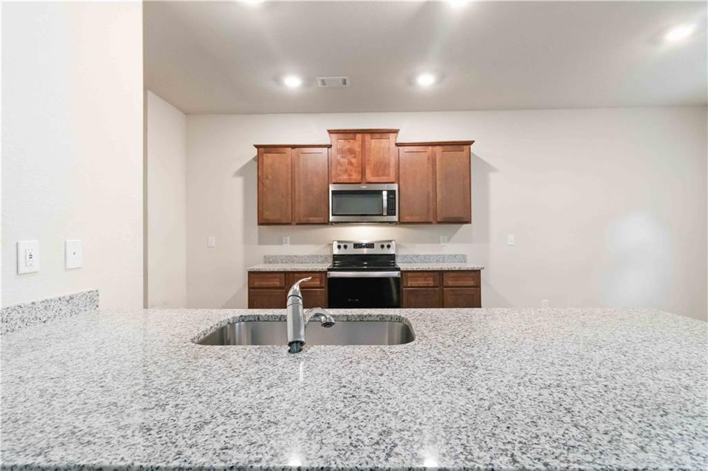 10794 Wheeler Trace Hampton, GA 30228 - Photo 14 of 35 a kitchen with stainless steel appliances a refrigerator sink and microwave
