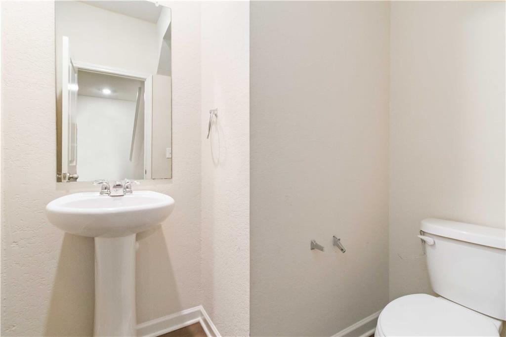 10794 Wheeler Trace Hampton, GA 30228 - Photo 17 of 35 a bathroom with a sink a toilet and mirror