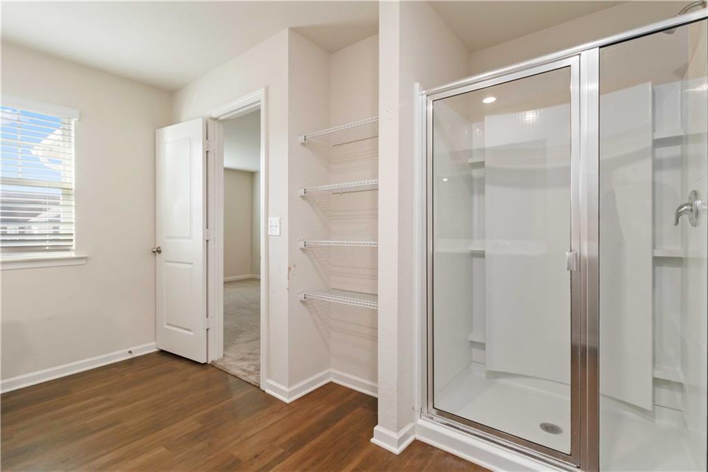 10794 Wheeler Trace Hampton, GA 30228 - Photo 29 of 35 a bathroom with a glass shower door