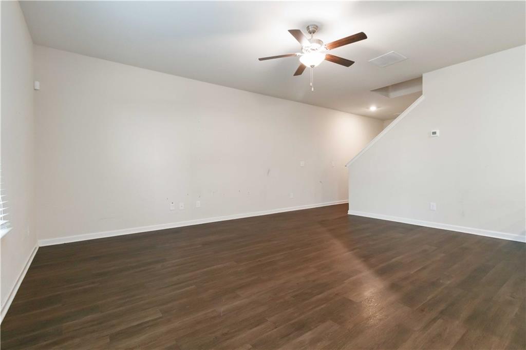 10794 Wheeler Trace Hampton, GA 30228 - Photo 9 of 35 an empty room with wooden floor and a ceiling fan