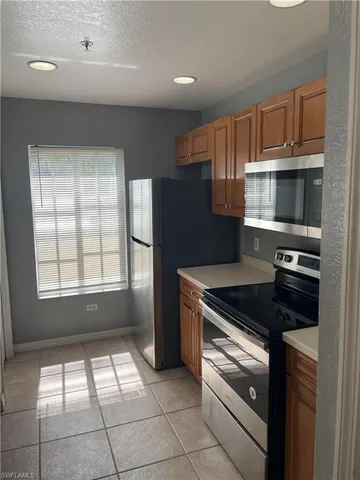 a kitchen with granite countertop a stove and a refrigerator