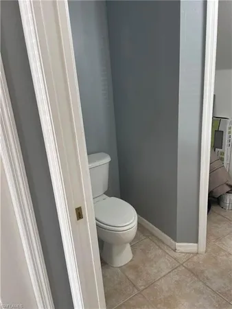 a white toilet sitting next to a small window