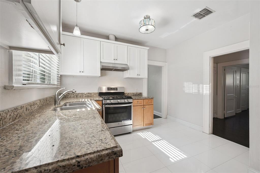 352 Cambridge Boulevard Winter Park, FL 32789 - Photo 12 of 35 a kitchen with granite countertop a sink stainless steel appliances and cabinets