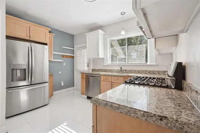 a kitchen with granite countertop a refrigerator and a sink