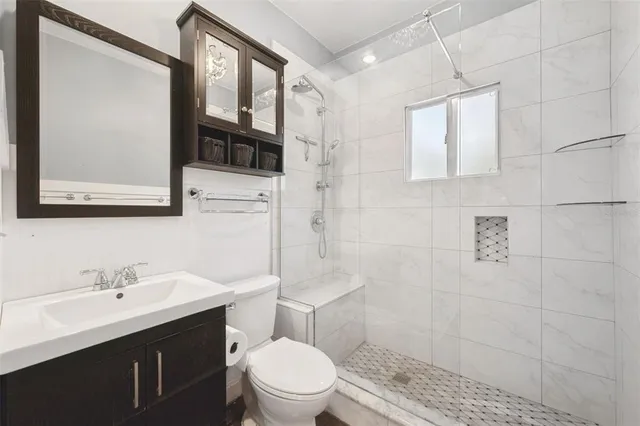 a bathroom with a toilet sink shower and mirror