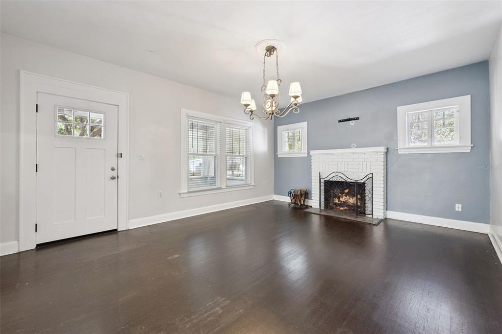 352 Cambridge Boulevard Winter Park, FL 32789 - Photo 4 of 35 an empty room with wooden floor fireplace and a window